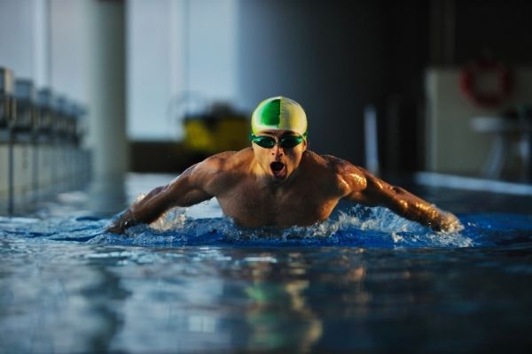 hombre nadando intensamente ejercitando musculos